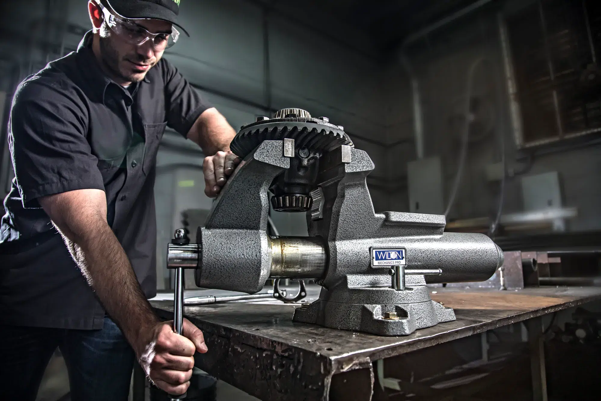 A man operates a machine in a workshop, showcasing Wilton's high-quality work holding solutions for precision tasks.